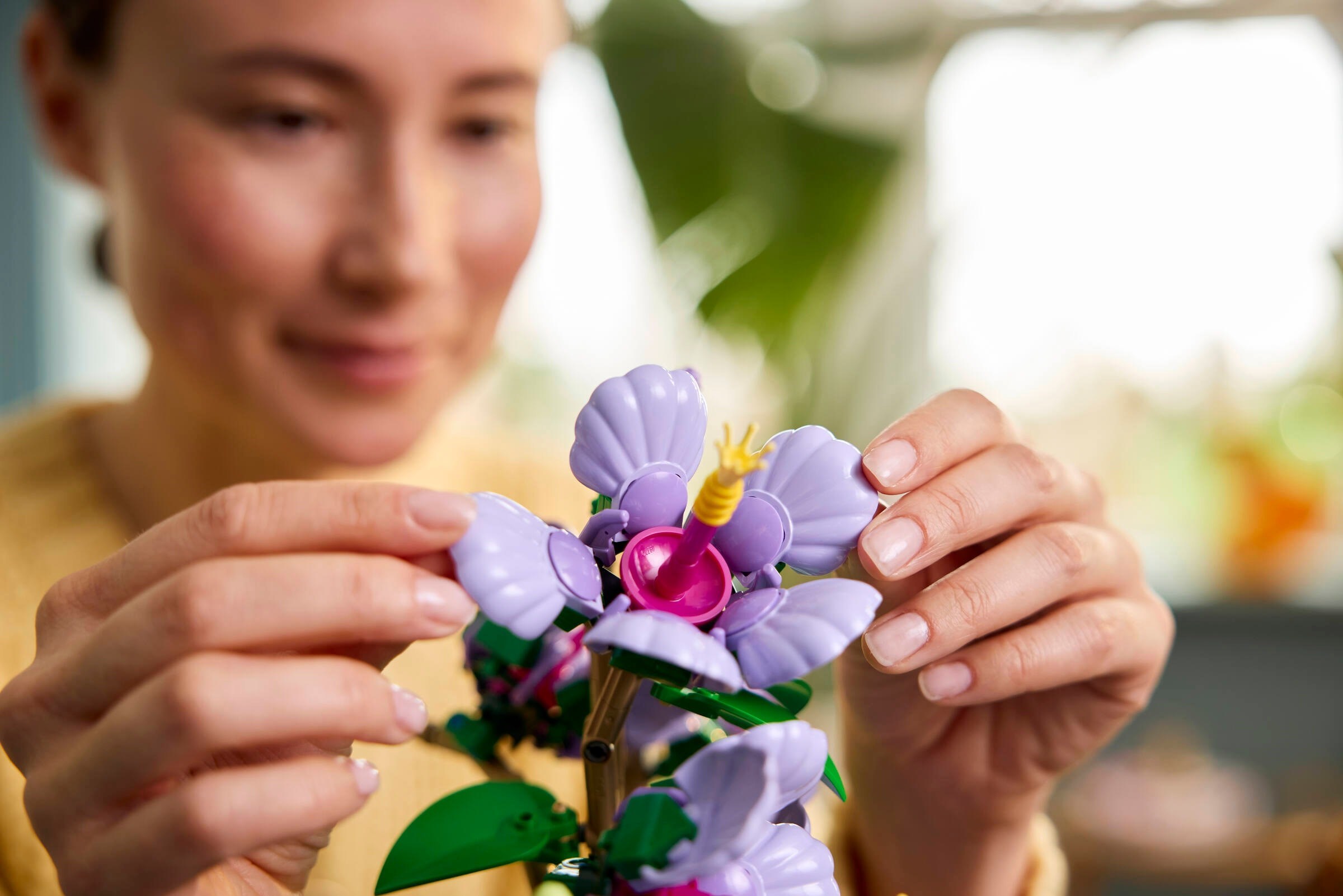 Hands-on building process showing assembly of LEGO 10372 Hibiscus flower with detailed petal construction