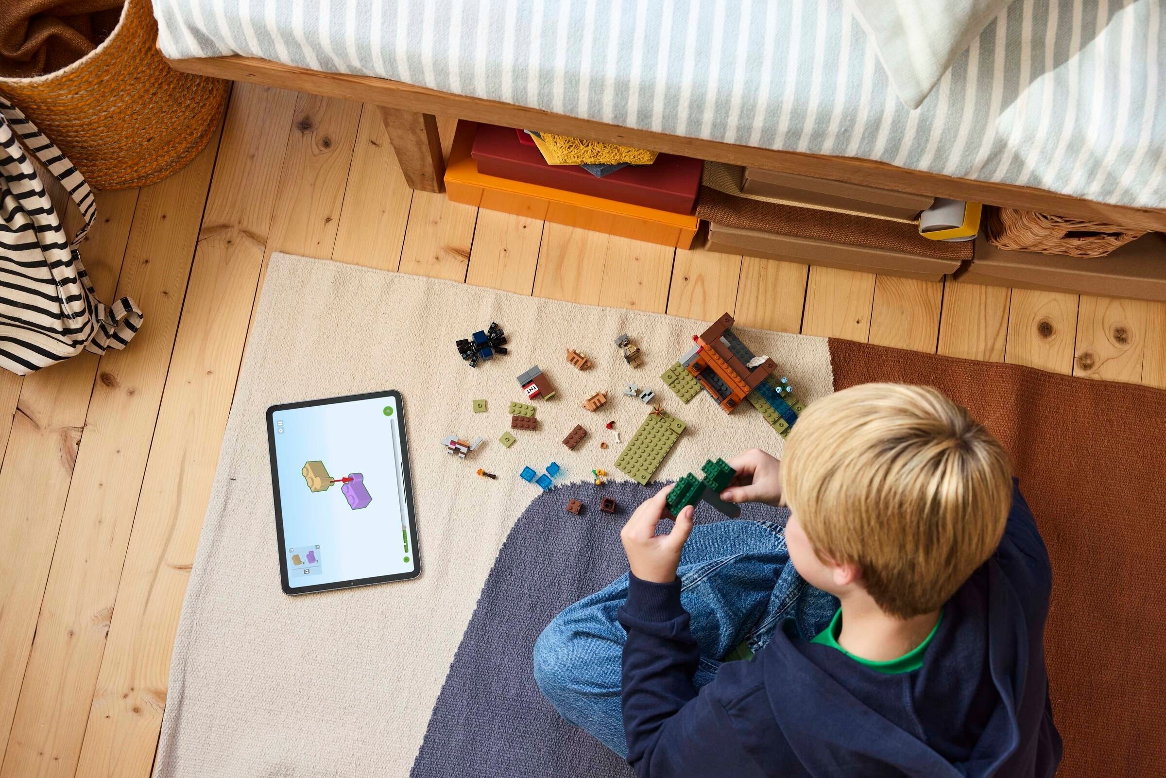 Child building LEGO Armadillo Mine Expedition set on floor