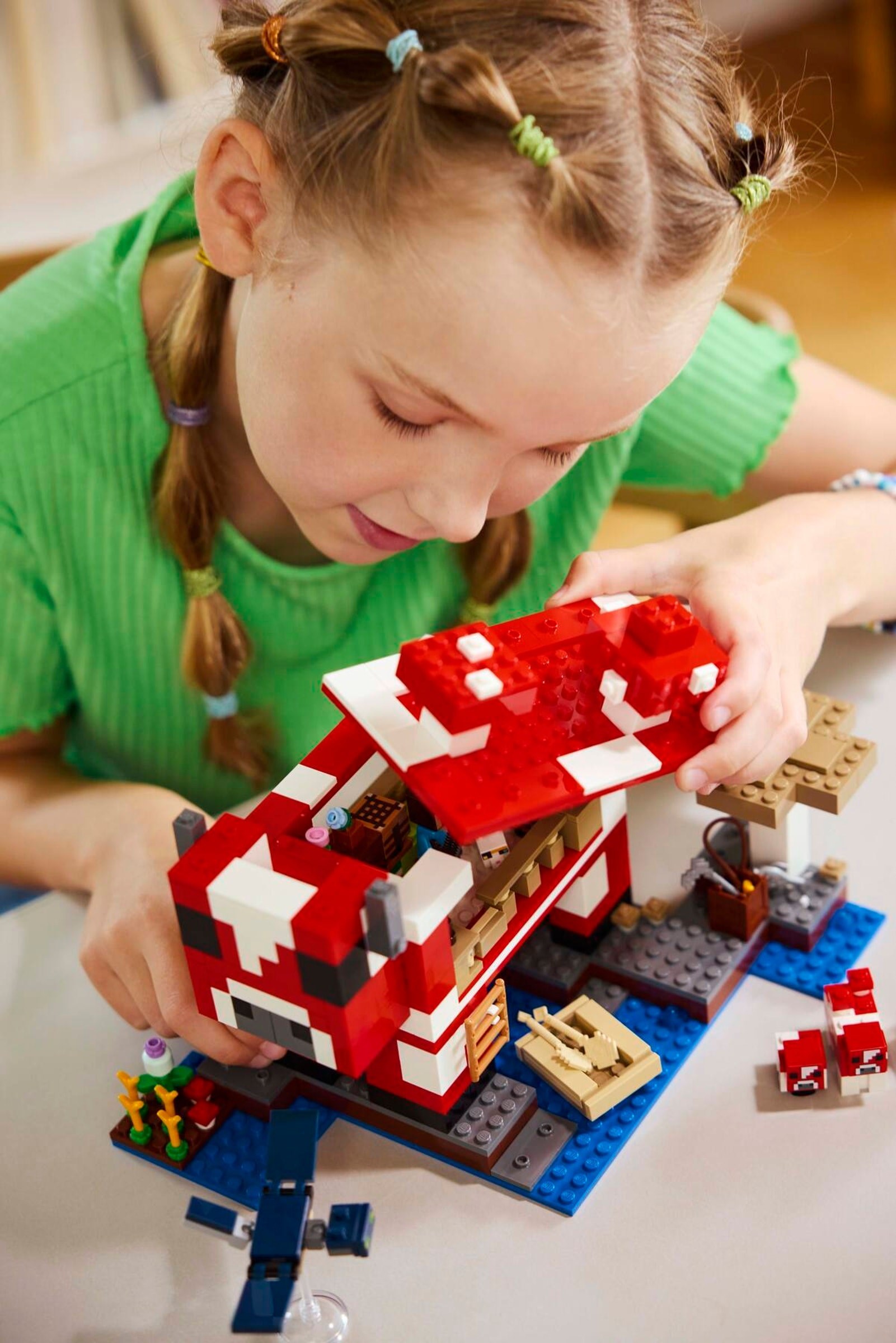 Child building LEGO Mooshroom House barn structure