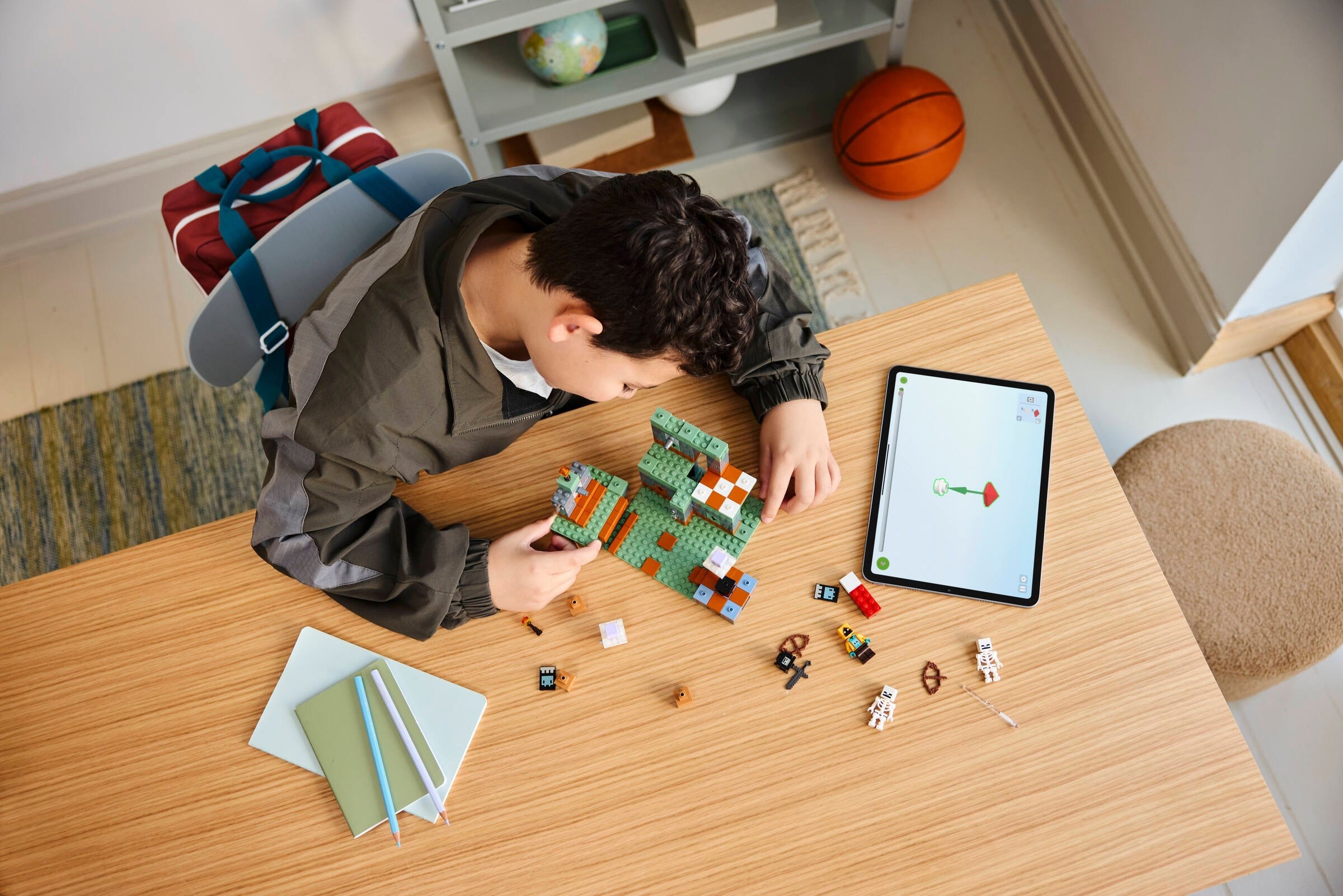 Boy building LEGO Trial Chamber at desk with tablet app