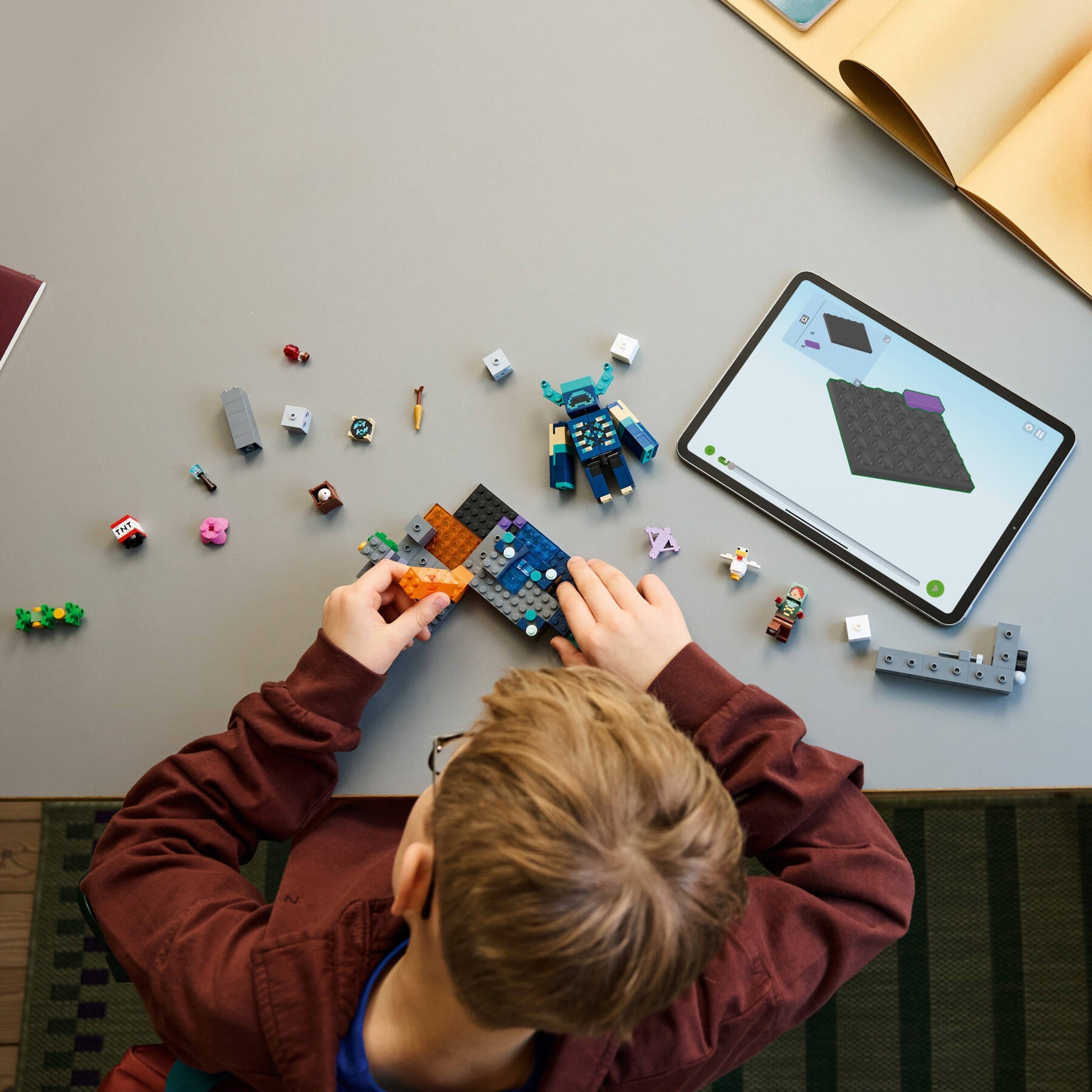 Child building LEGO Warden Encounter with tablet app guidance